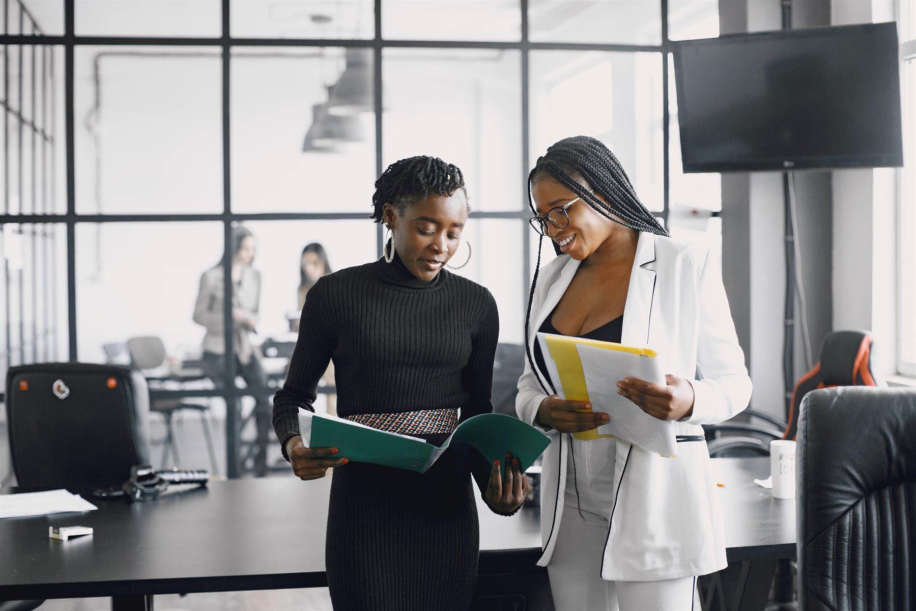 Black women executives collaborating in a modern office
